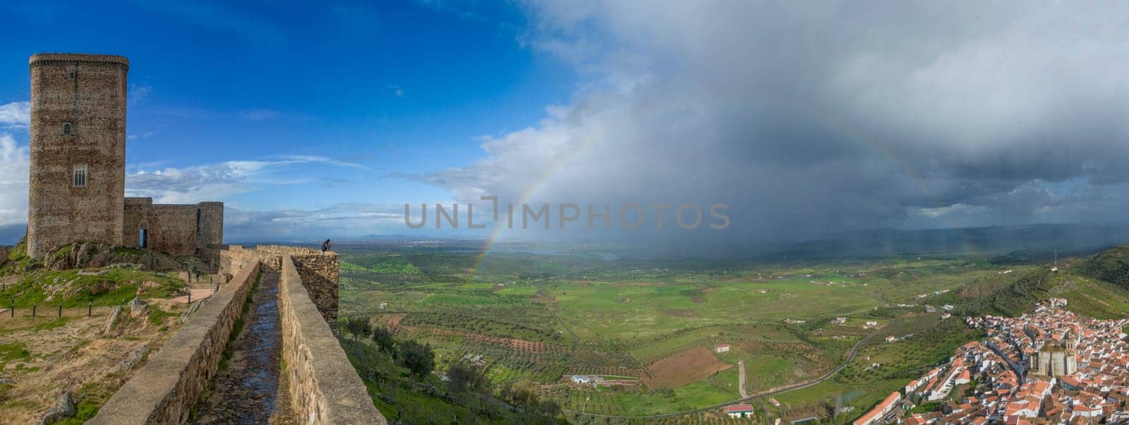 Panoramic of Feria, Badajoz, Spain. The rainbow stretches from the castle to the village