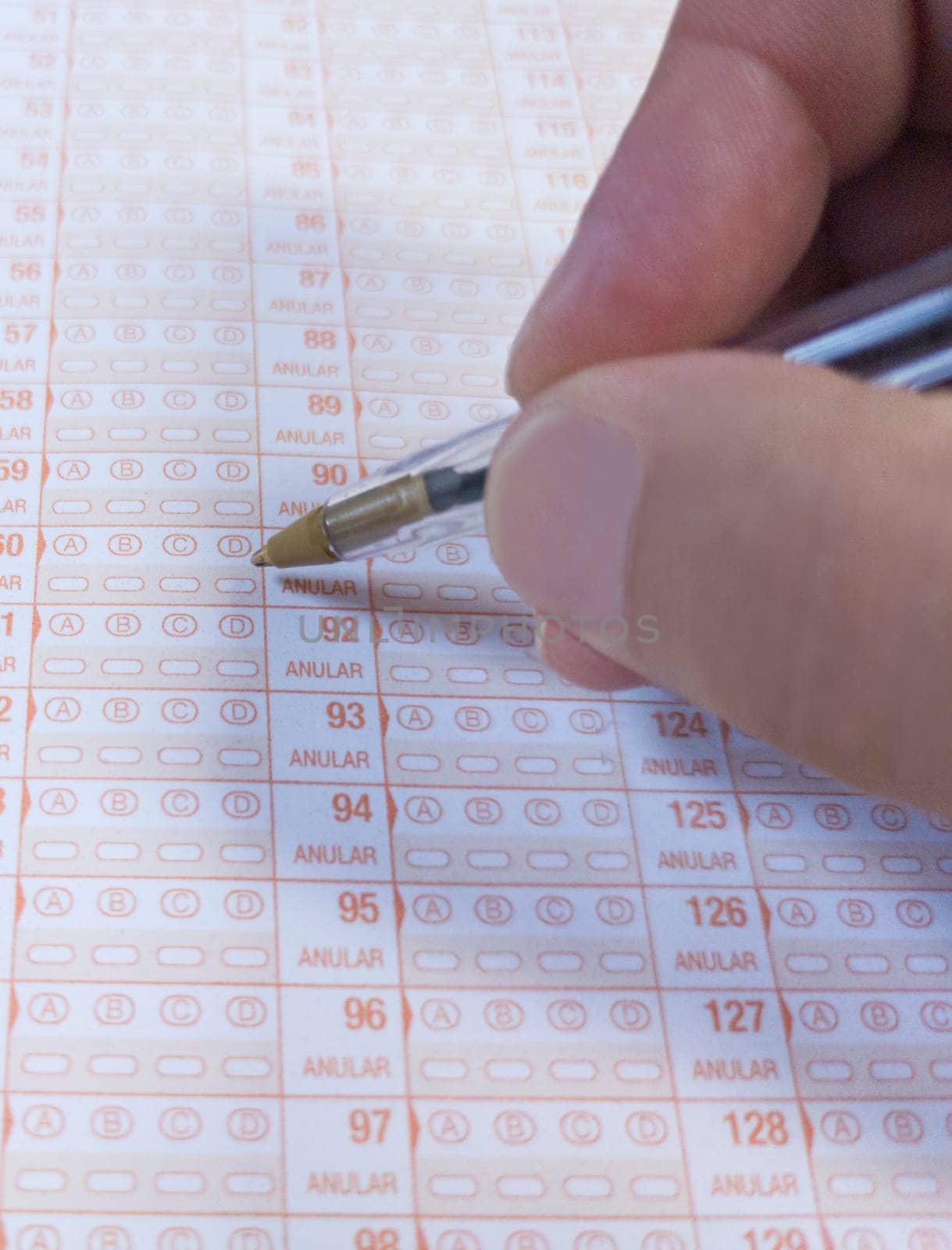 Candidate hand holds a ballpen over multiple-choice test. Public examination concept