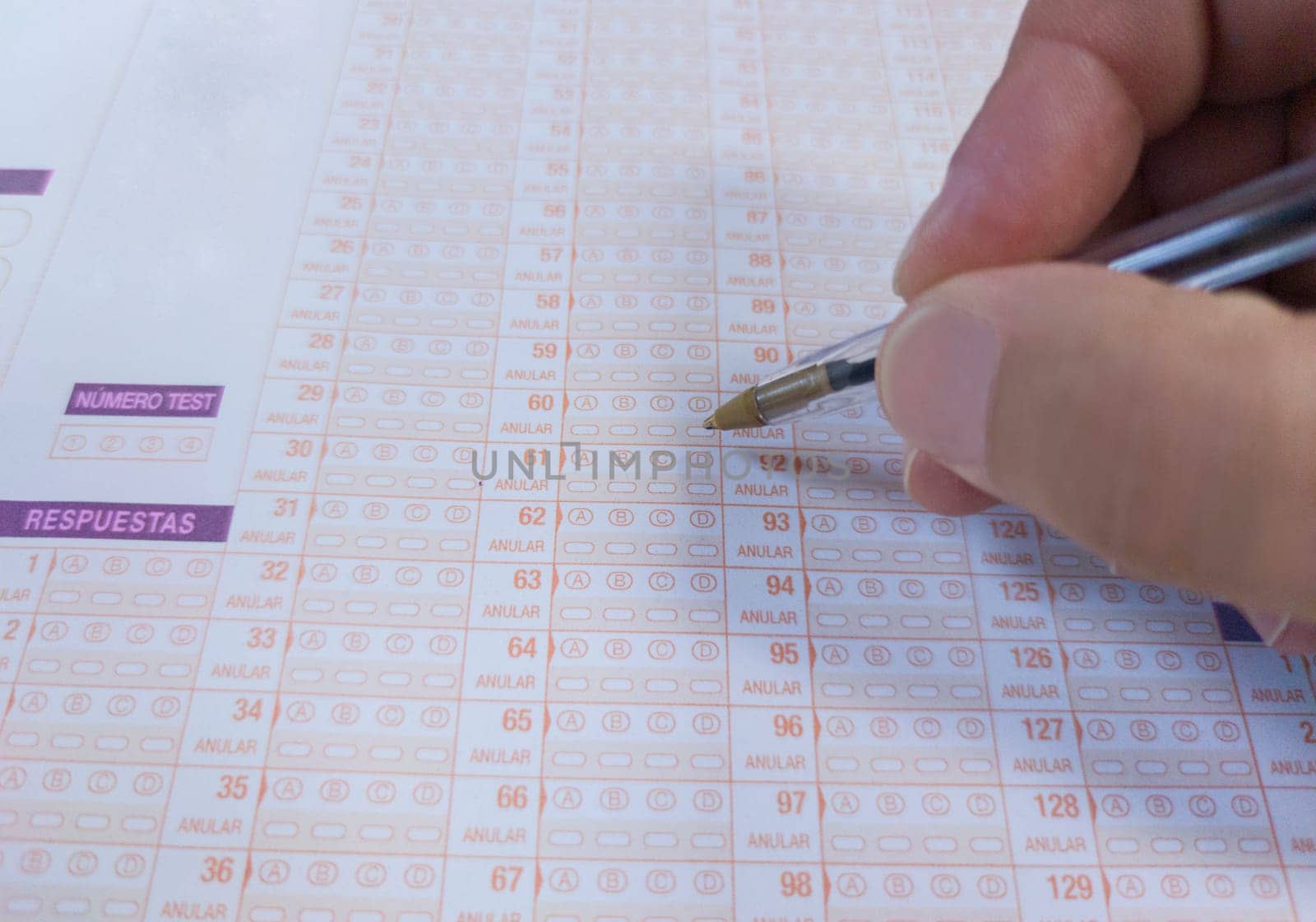 Candidate hand holds a ballpen over multiple-choice test. Public examination concept