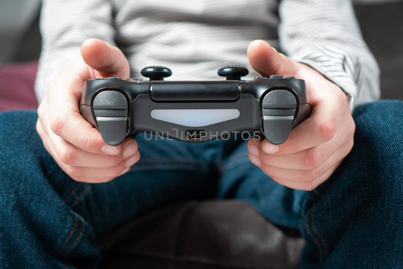 Male hands hold modified plastic joystick closeup, selective focus. Person play videogames. Hold wireless game console. Press buttons on controller by fingers. Modern technologies and gaming.