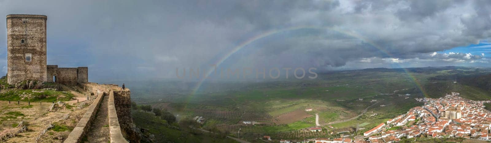 Panoramic of Feria, Badajoz, Spain. The rainbow stretches from the castle to the village