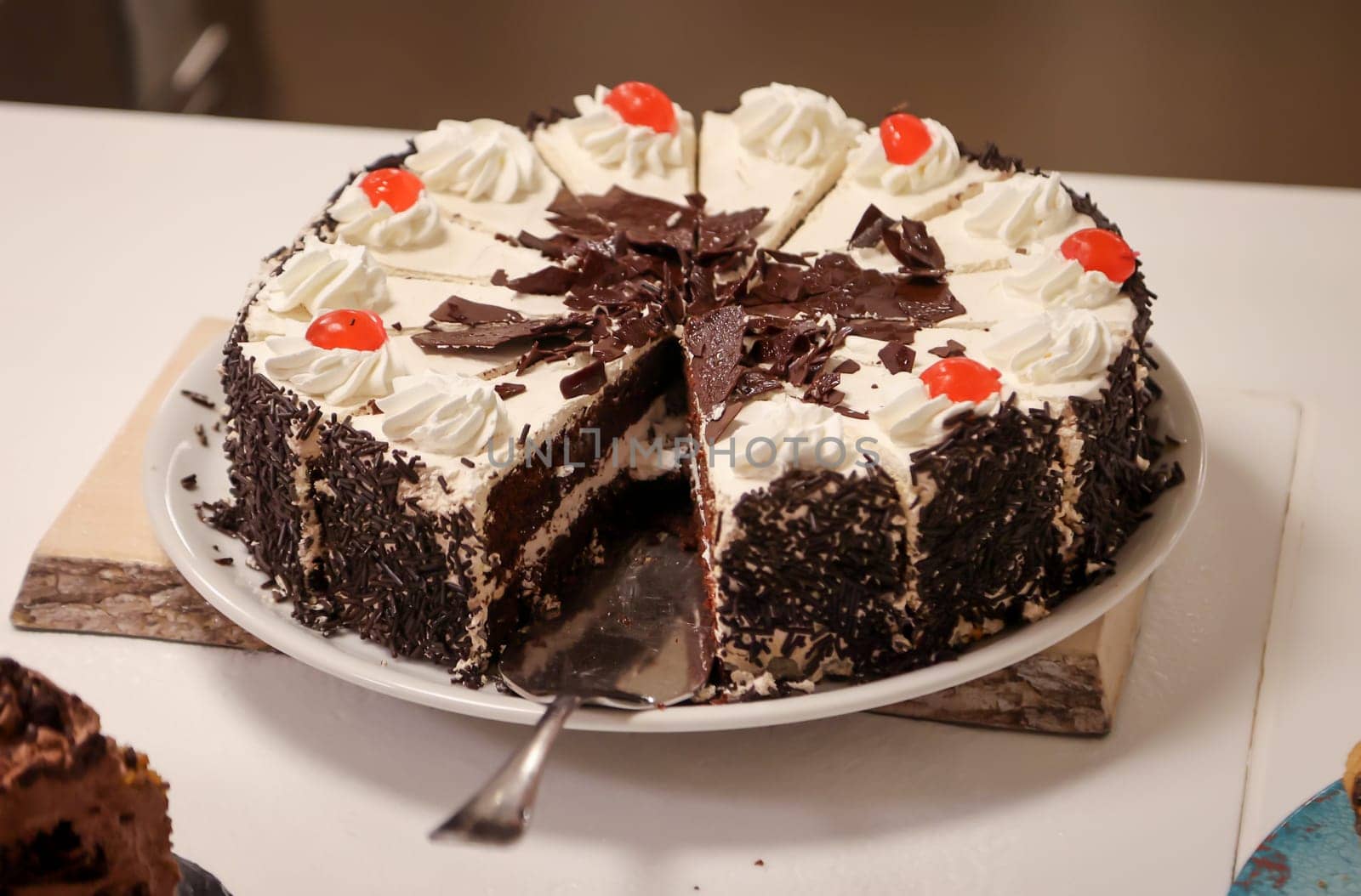 A cut chocolate cream cake with pieces already missing.