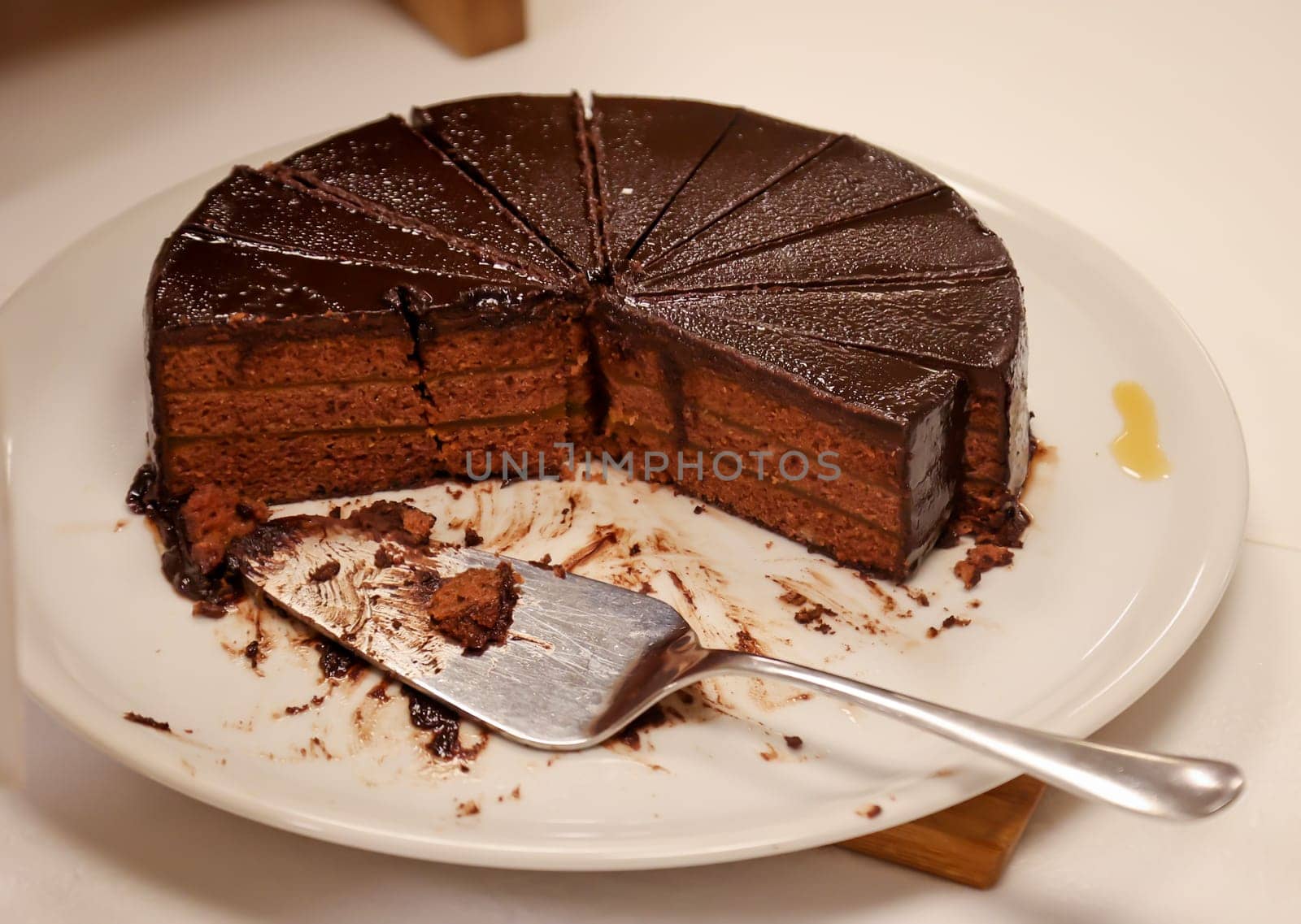 A cut chocolate cream cake with pieces already missing.