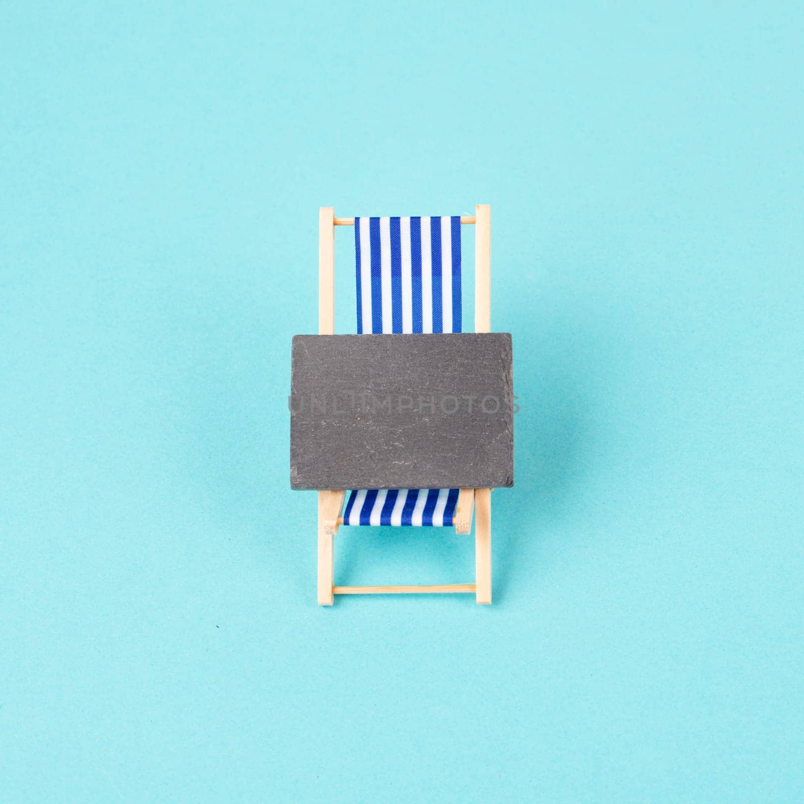 Lounge chair with a blank chalkboard sign, summer vacation travel by the sea