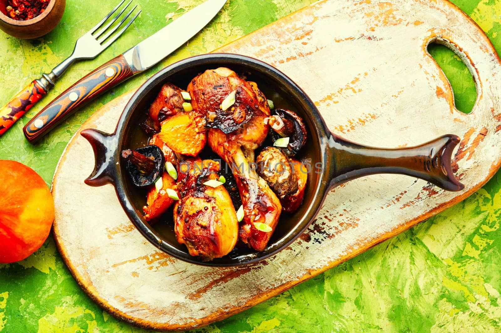 Chicken drumsticks baked with pumpkin on the plate. Copy space