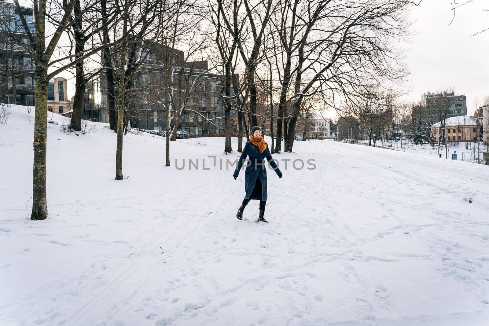 A cheerful woman against the backdrop of a winter city during a walk.