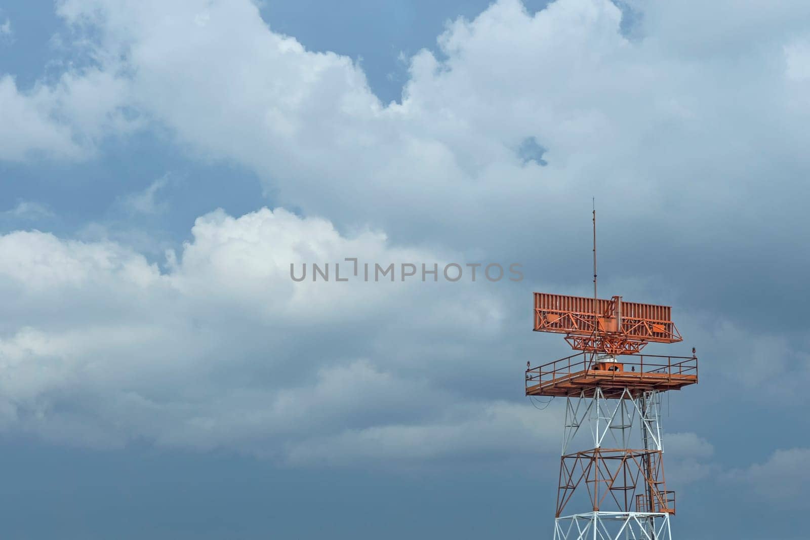 Red-and-white airport radar in daylight
