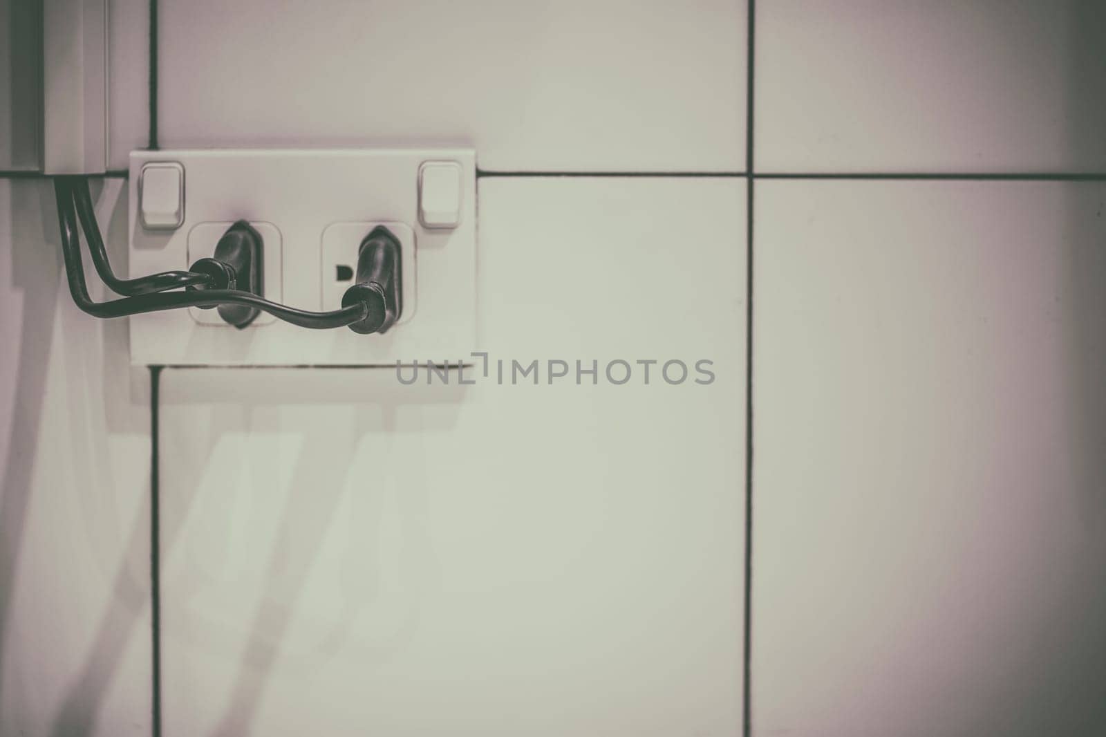 The old electrical plug next to the cream wall.