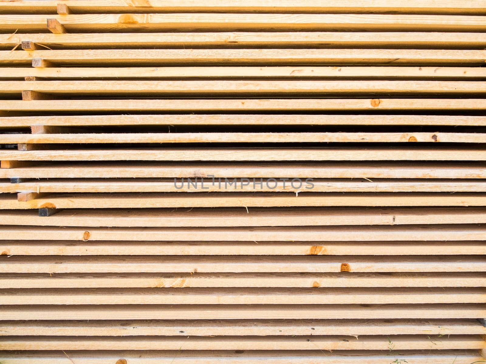 Full framed view of new softwood boards stacked parallel on top of each other.