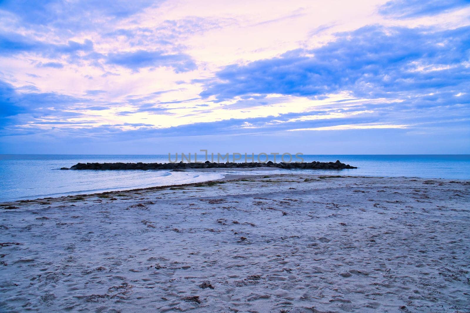 Hundested, Denmark on the cliff overlooking the sea. Baltic Sea coast, grassy meadow, beach. Clouds on horizon. Landscape photo from Scandinavia.