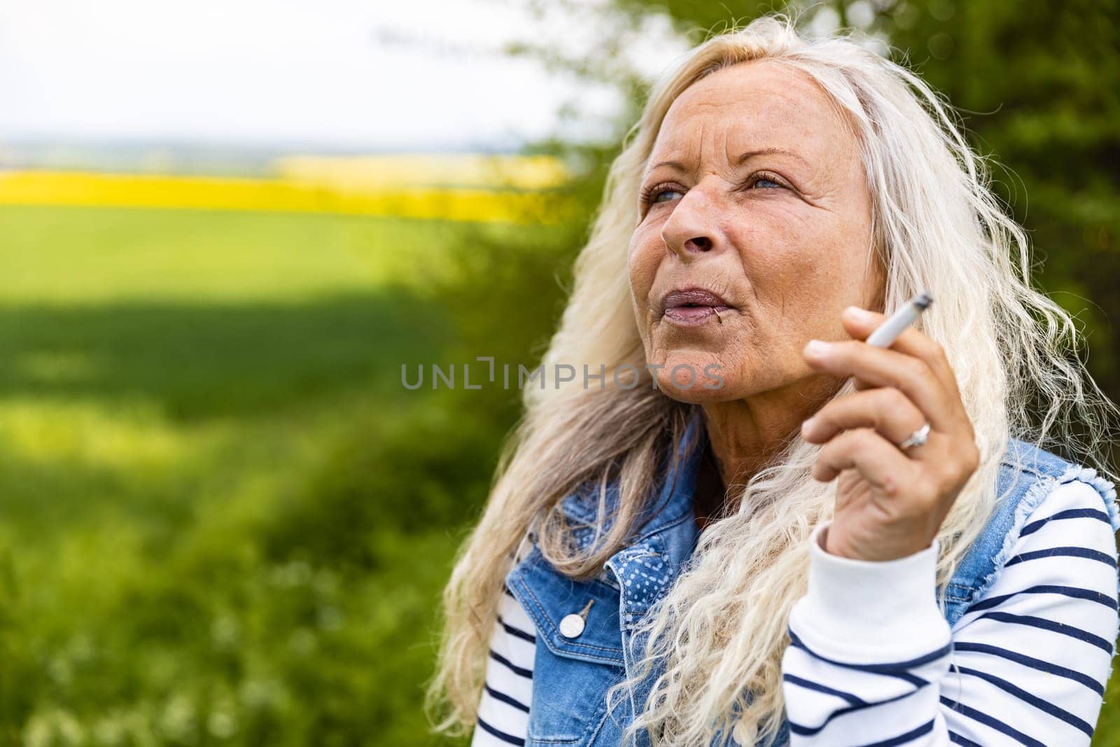 Portrait from a Lady smoking outdoor a cigarette.