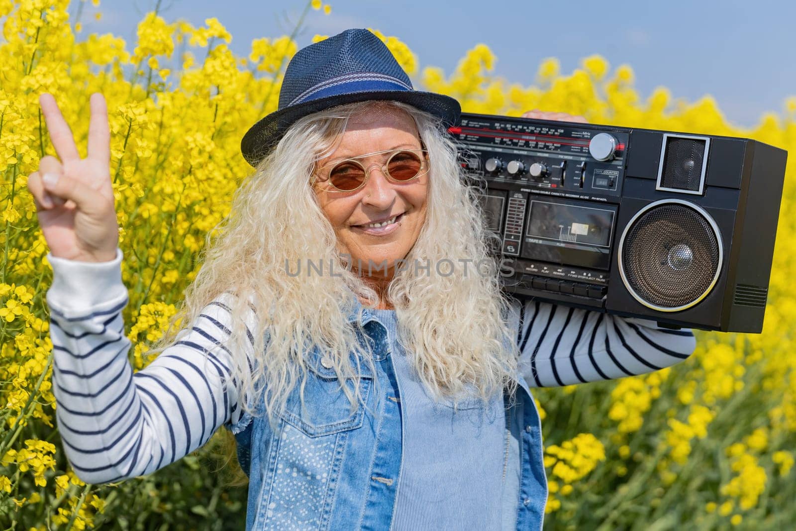 Elderly Woman have fun with vintage Boom Box in Nature.