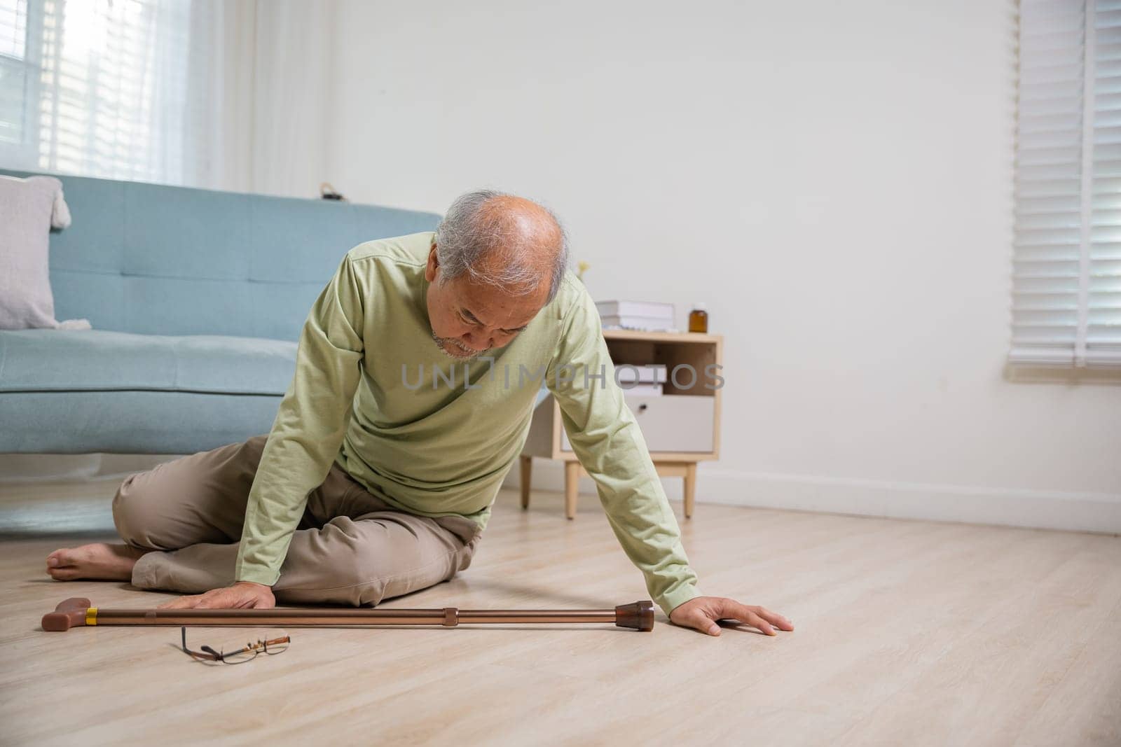 Older senior man headache lying on the floor after falling down he pain and hurt from osteoporosis, Elderly man falling on the floor alone with walking stick at home, Health care and medicine