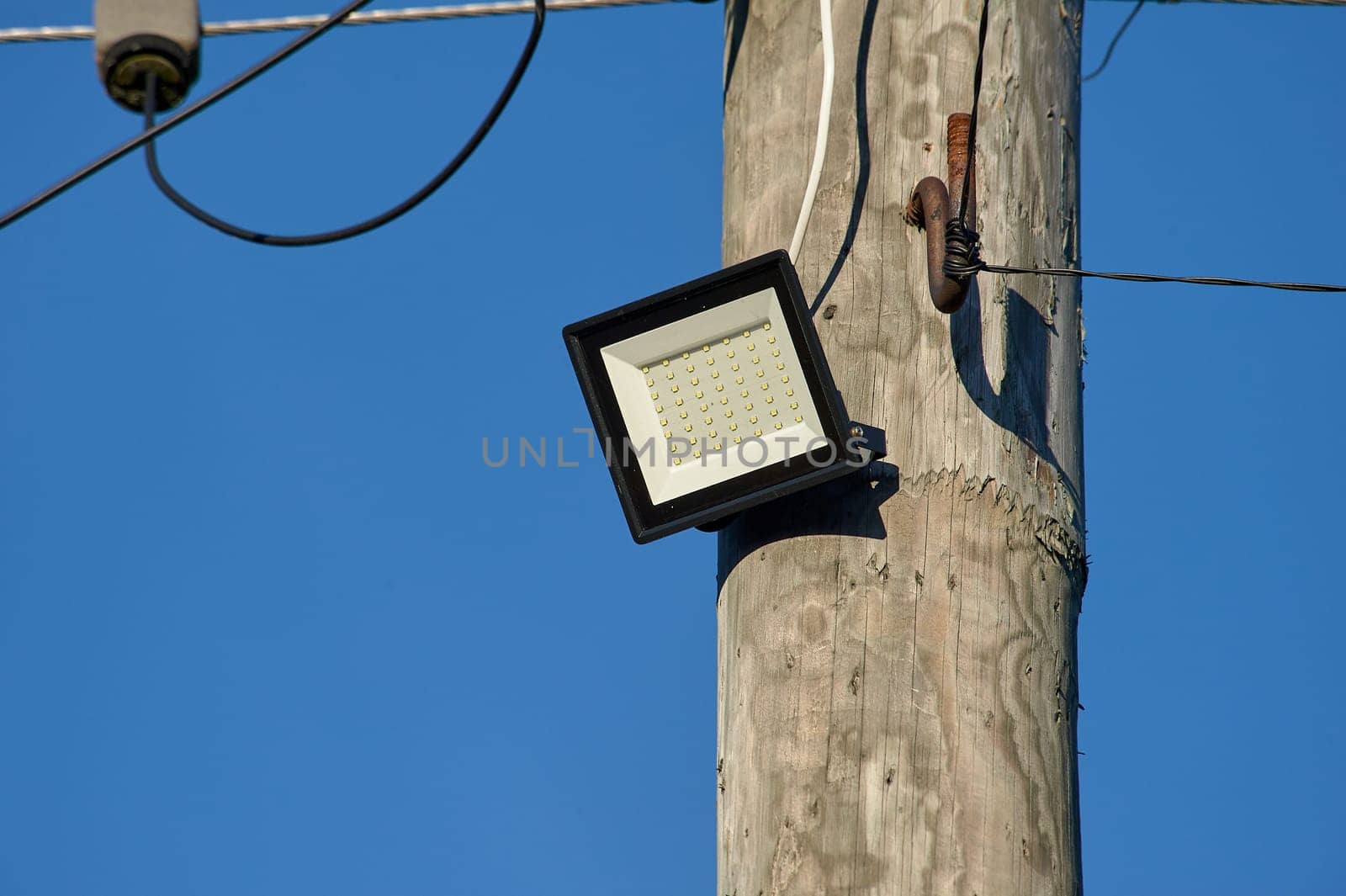 The LED street light is attached to a wooden pole