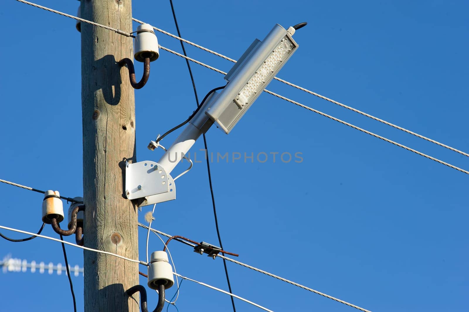 The LED street light is attached to a wooden pole. High quality photo
