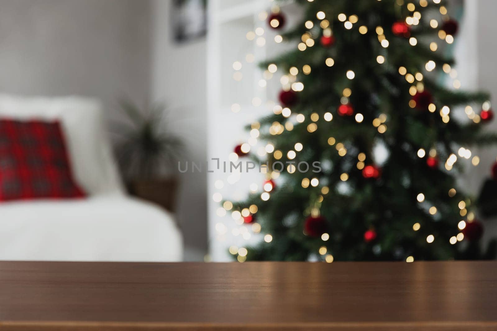 Christmas, New Year background with copy space for design. Empty wooden tabletop surface, blurred Christmas fir tree composition, bokeh sparkle lights effect. Mockup ready for product montage