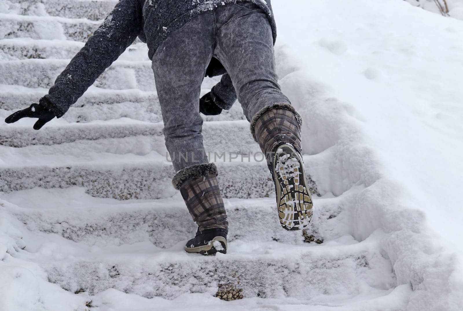 A woman slips on a snow covered staircase