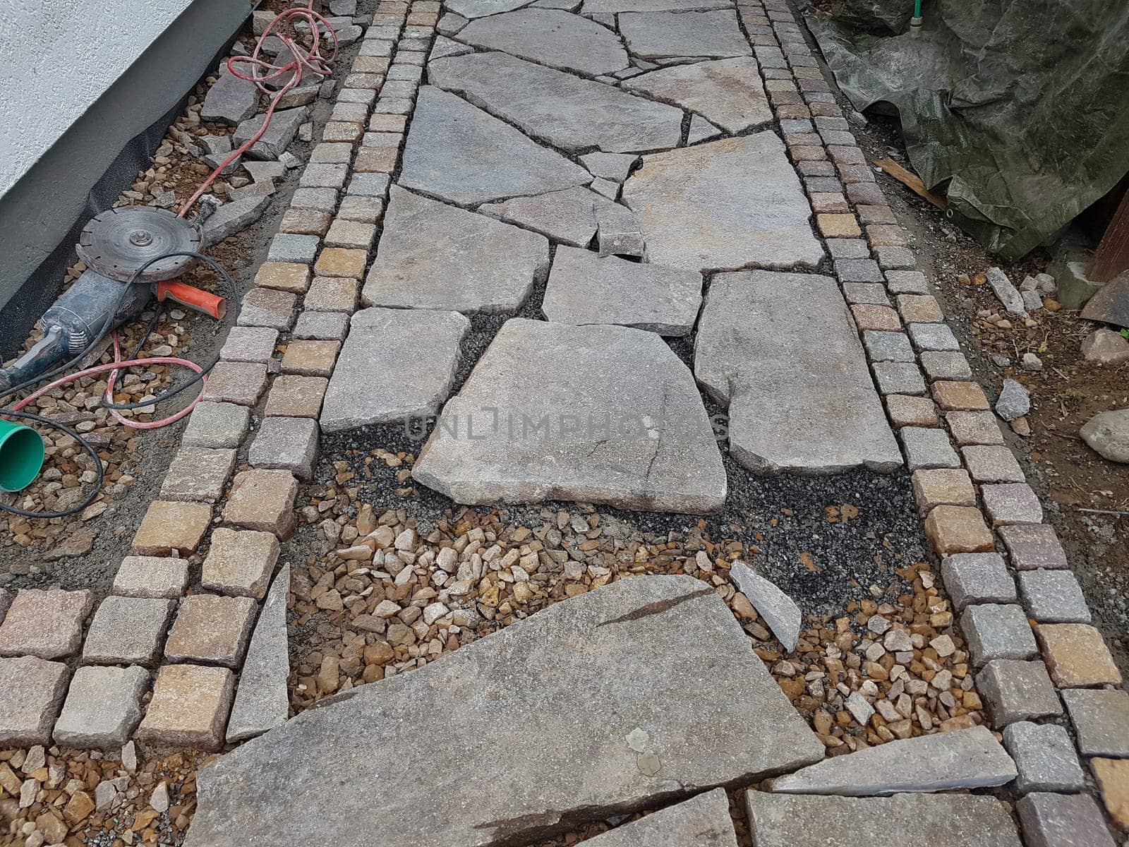 Garden path,made of porphyry slabs and cobblestones under construction. Garden path,made of porphyry slabs and cobblestones under construction