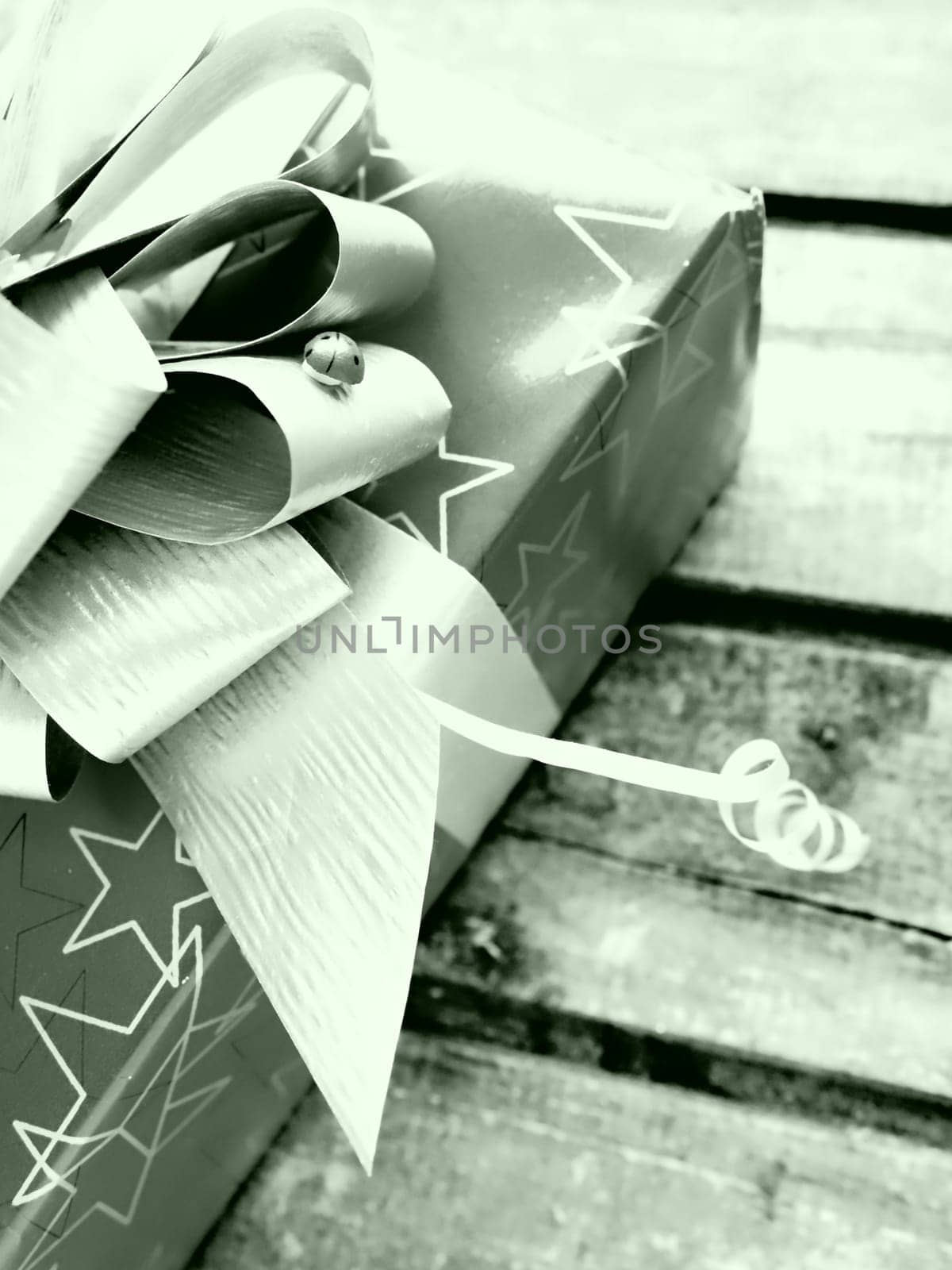 Gift box with a large bow on a wooden background. Gift for Christmas, New Year, Birthday, Mother's Day, Wedding, Valentine's Day. Beautiful festive decoration. Give gifts. Green tint. White and black
