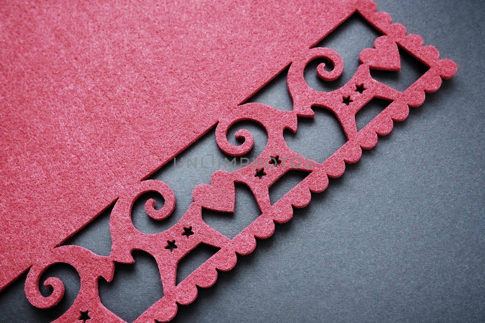 Background New Year's or for Valentine's Day. Kissing goats with stars and hearts are carved on red felt fabric. Merry Christmas and Happy New Year. Postcard, congratulation or invitation. Copy space.