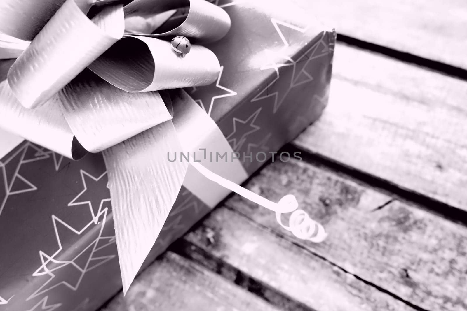 Gift box with a large bow on a wooden background. Gift for Christmas, New Year, Birthday, Mother's Day, Wedding, Valentine's Day. Beautiful festive decoration. Give gifts. Purple tint monochrome