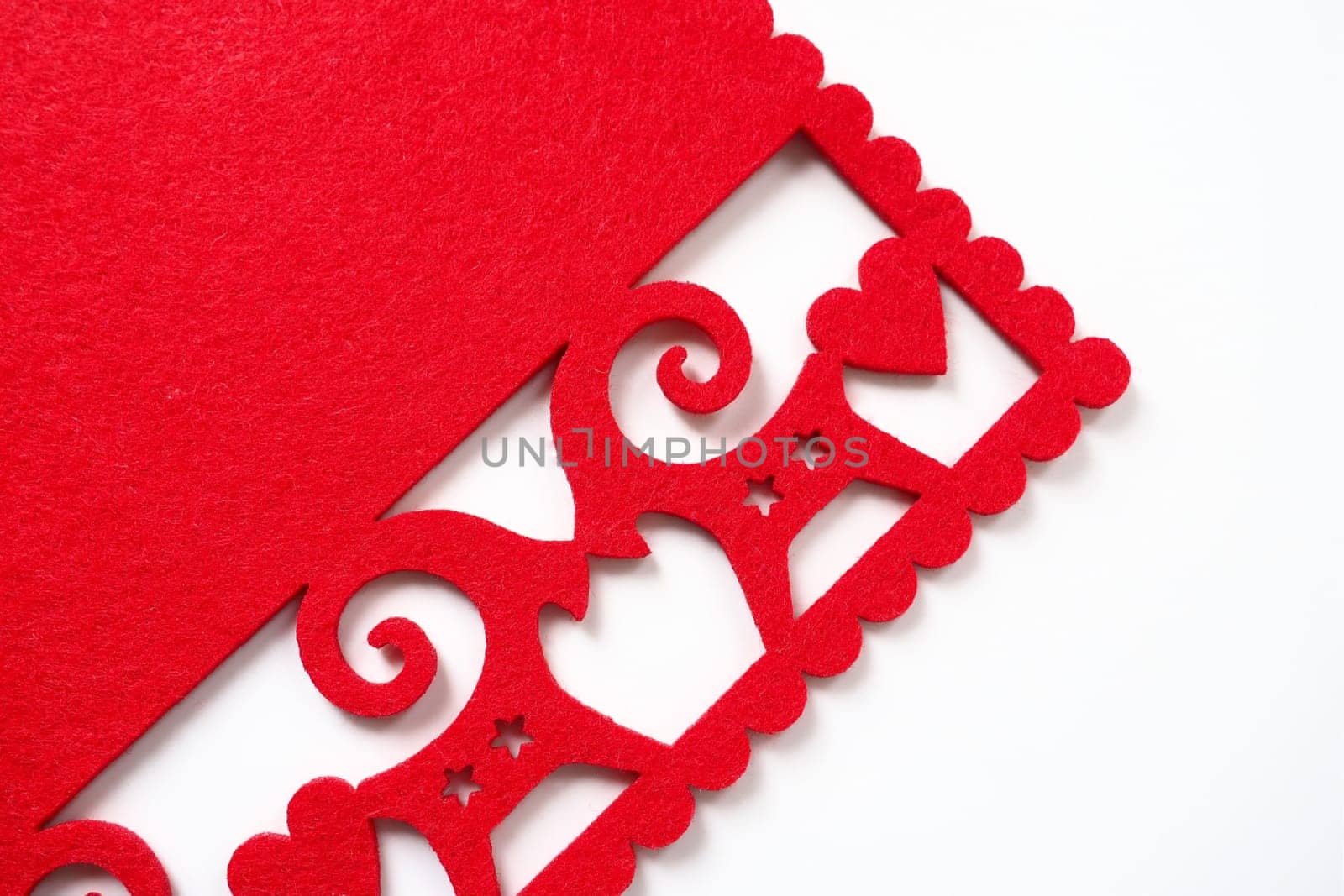 Background New Year's or for Valentine's Day. Kissing goats with stars and hearts are carved on red felt fabric. Merry Christmas and Happy New Year. Postcard, congratulation or invitation. Copy space