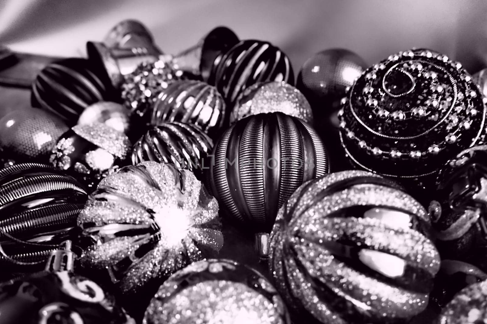 Christmas flat lay with Xmas decorations and holiday beautiful balls. Christmas tinsel. Happy New Year and Merry Christmas. Black and white monochrome photo with lilac filter. Still life background.