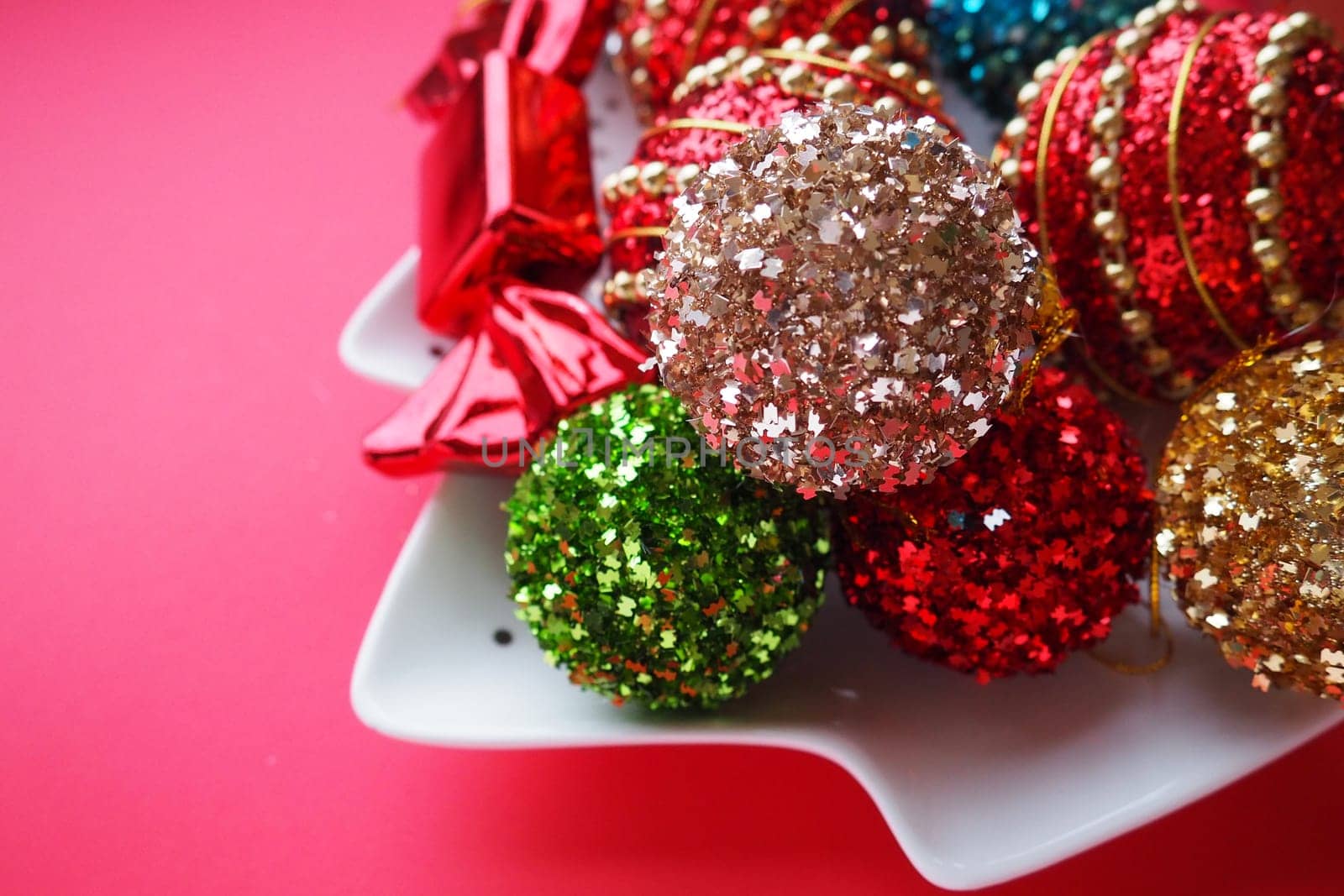 Christmas background with Christmas decorations, holiday balls, bells, bows, fir cone, Christmas tree rain. Happy New Year and Merry Christmas. Red, brown, striped, green, gold, purple, colorful decor