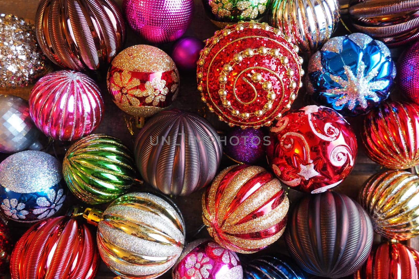 Christmas decorations. Beautiful red, golden, yellow balls with sparkles and stripes. Preparing for the New Year and Christmas holidays. Beautiful decorations. Flat lay and still life. Modern style
