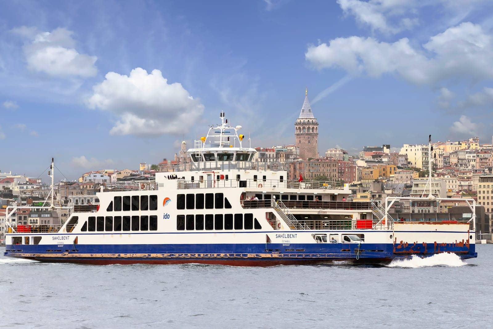 Istanbul, Turkey - August 25, 2022: Modern ferry boat sailing in Bosphorus Strait with Galata Tower in the background