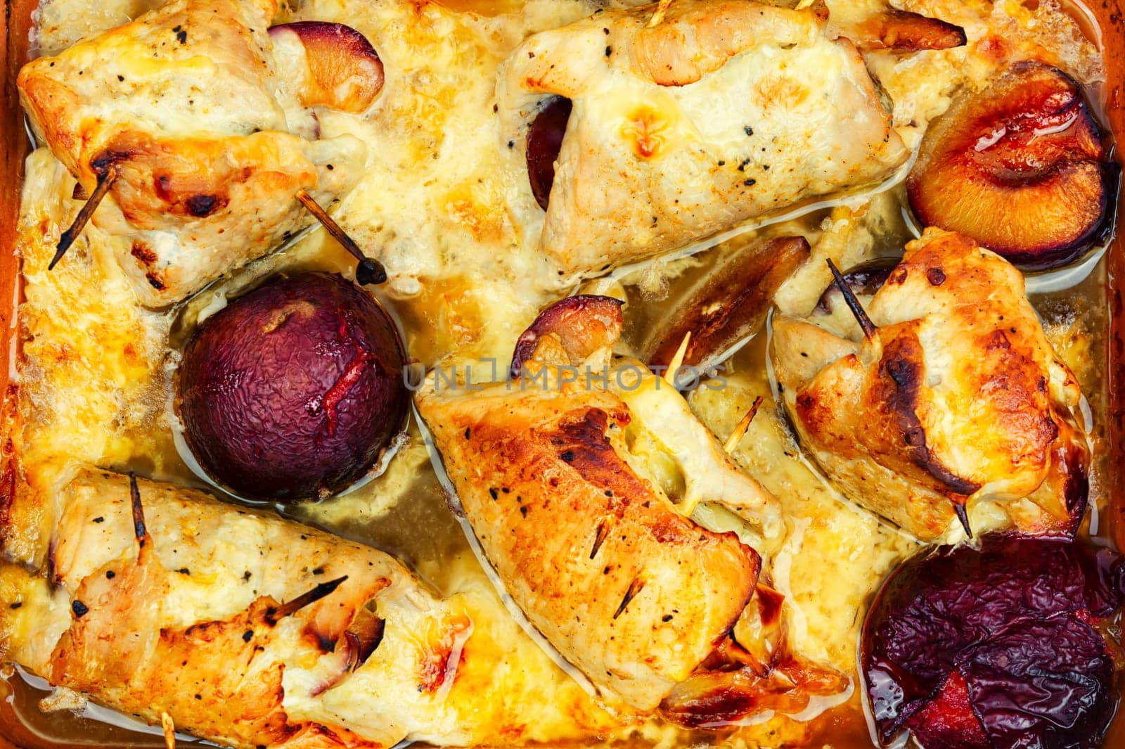Appetizing meat rolls baked with plum filling on a plate