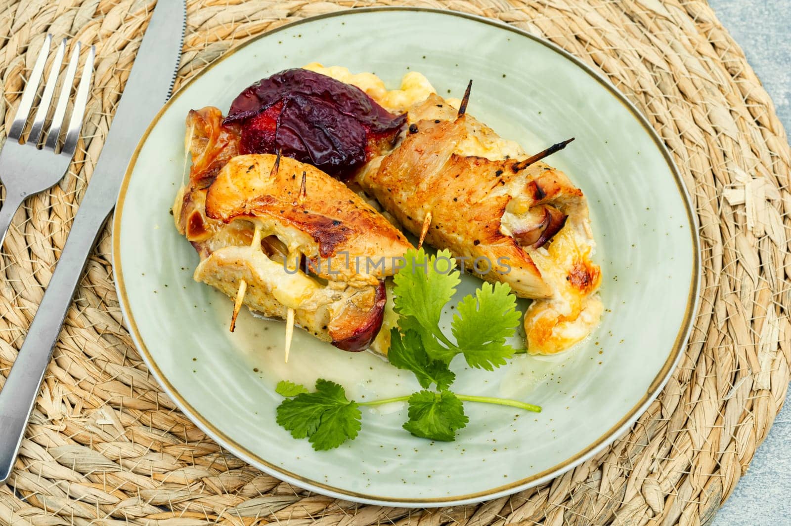 Appetizing meat rolls baked with plum filling on a plate