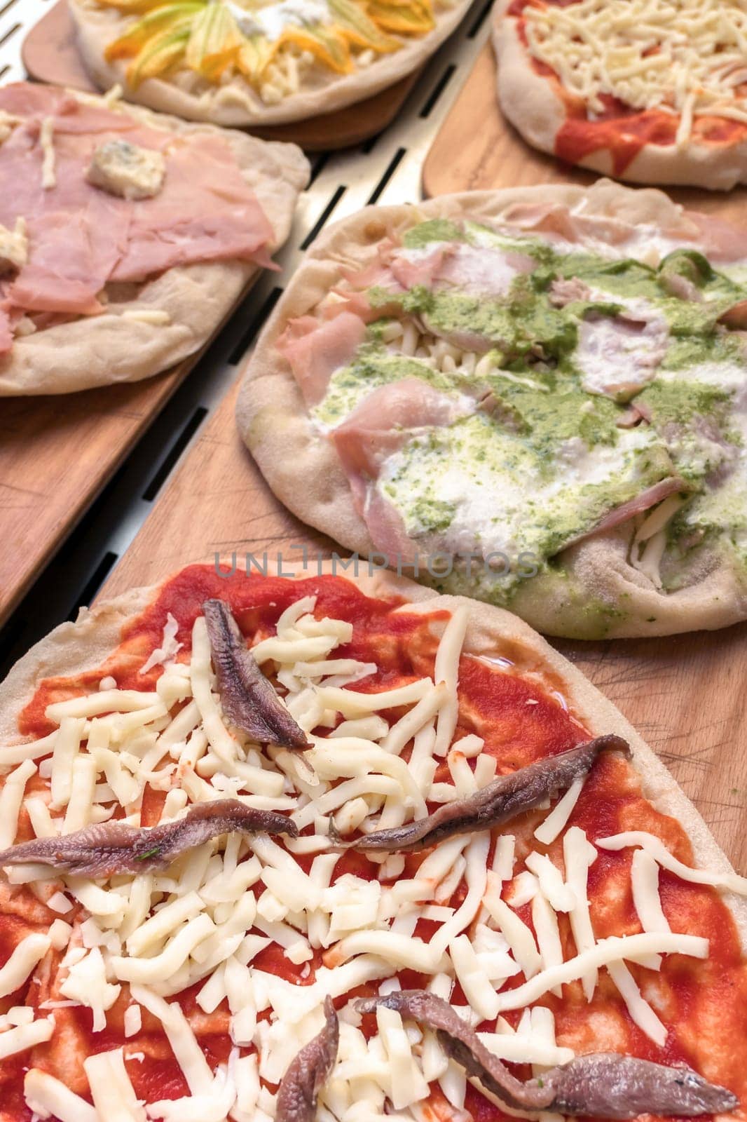 Variety of raw pizzas to bake. Restaurant. Pizzeria. Italian food.