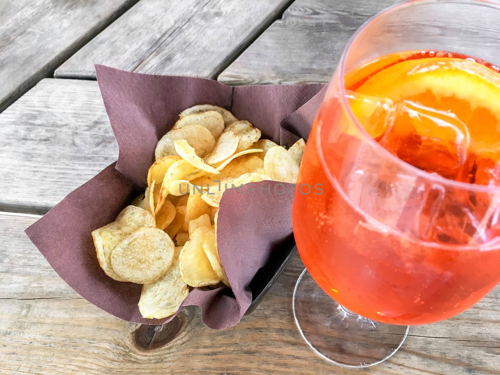 Spritz Aperol with chips, for a perfect pre-dinner. Classic Italian aperitif.