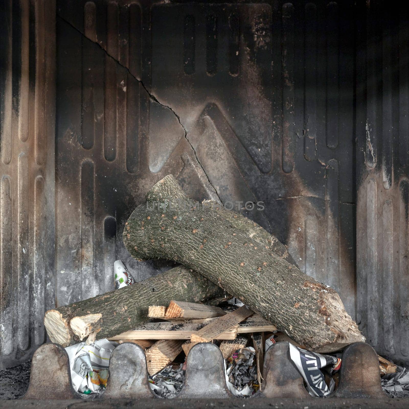 Unlit fire place and non burning logs inside background. Unlit fireplace. Fireplace off. Ready for fire.