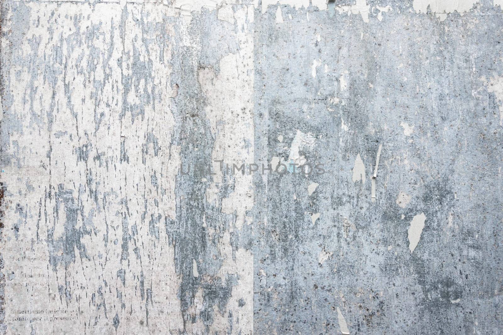 Grunge ripped poster background - texture of torn advertisement on an old rusty billboard panel.
