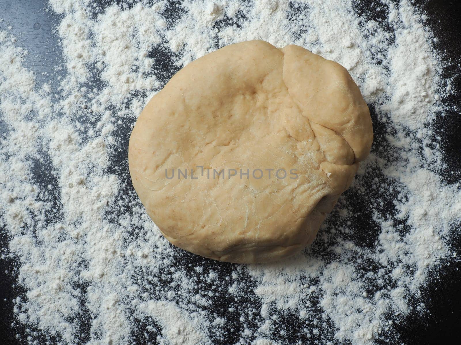 Fresh yeast dough with flour on a kitchen countertop