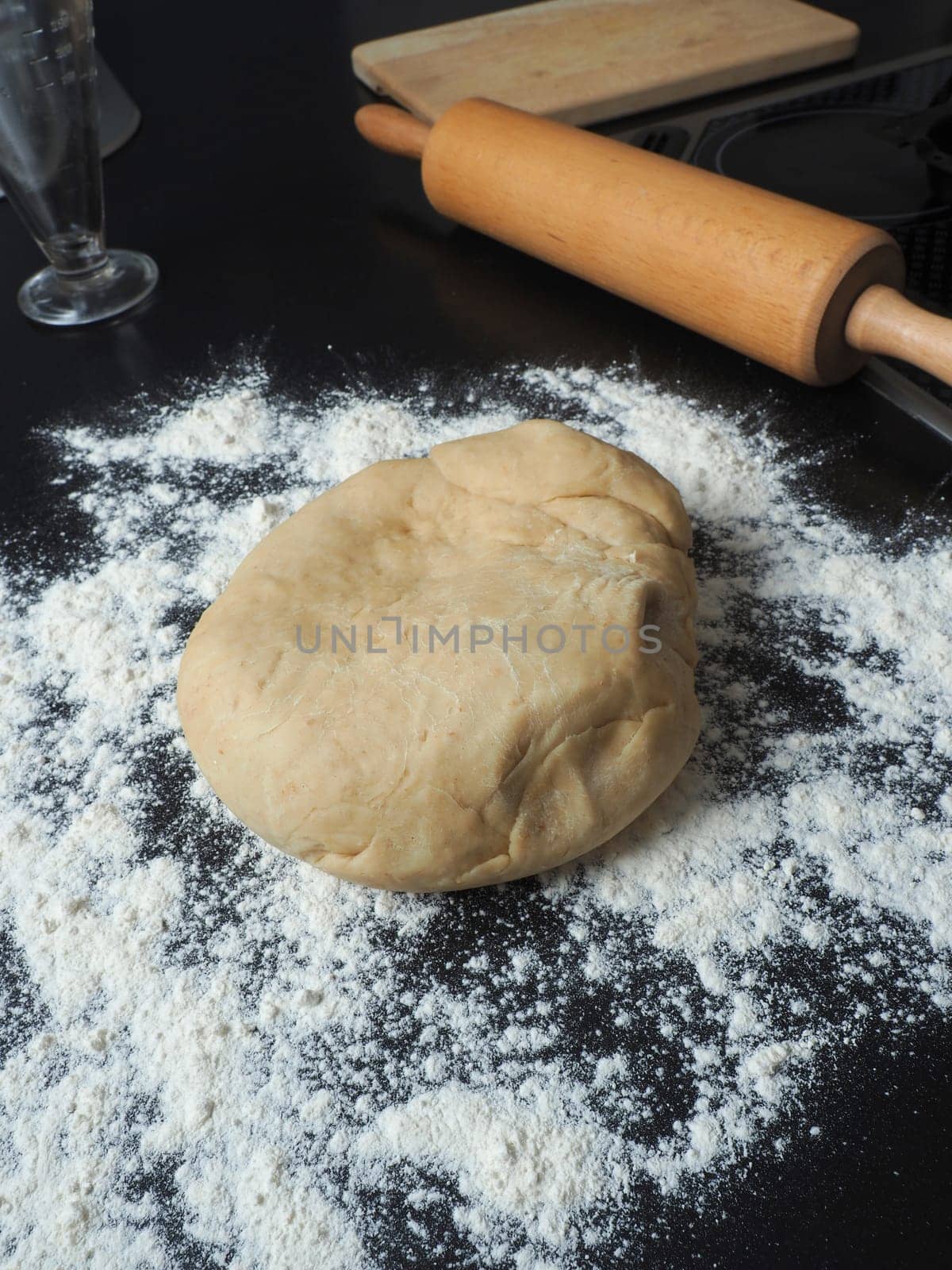 Fresh yeast dough with flour on a kitchen countertop