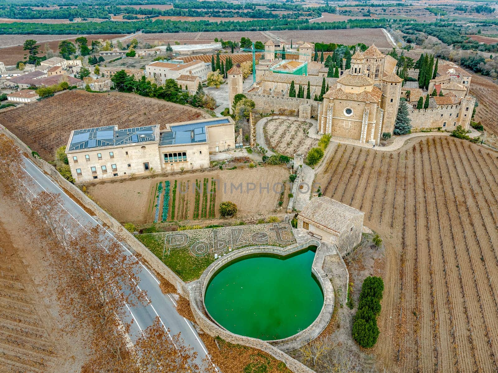 Monastery of Santa Maria de Poblet, Catalonia, Spain, General aerial view taken from the irrigation pond with the detail of Poblet written in white stone