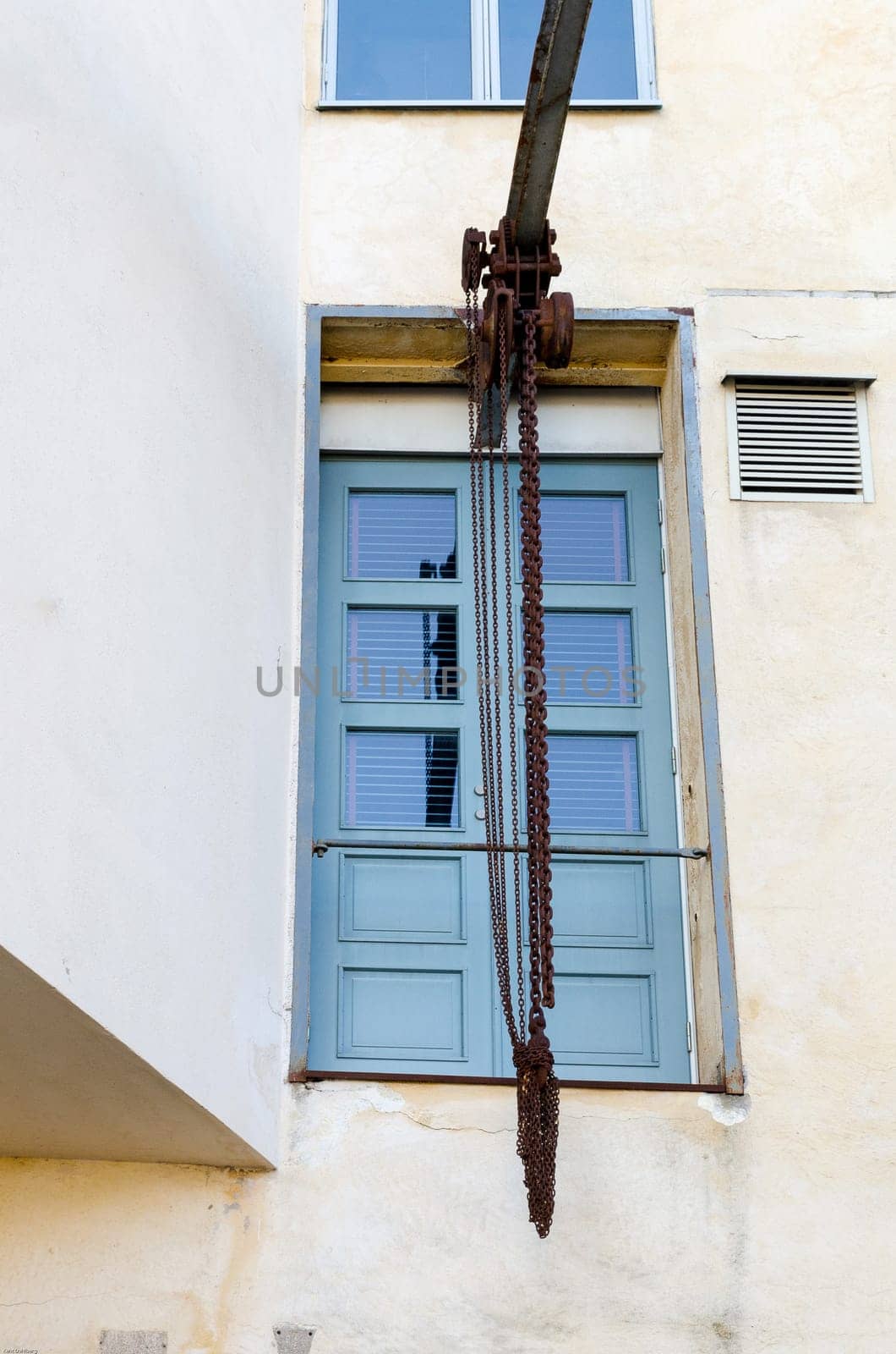one old pulley with a rusty chain ready to lift