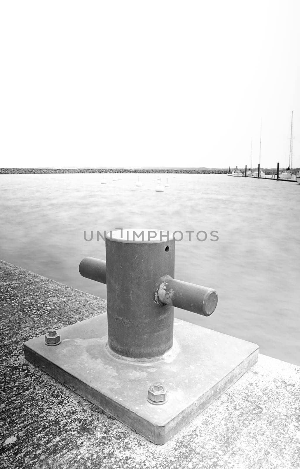 Long time exposure in a marina with a bollard in foredground