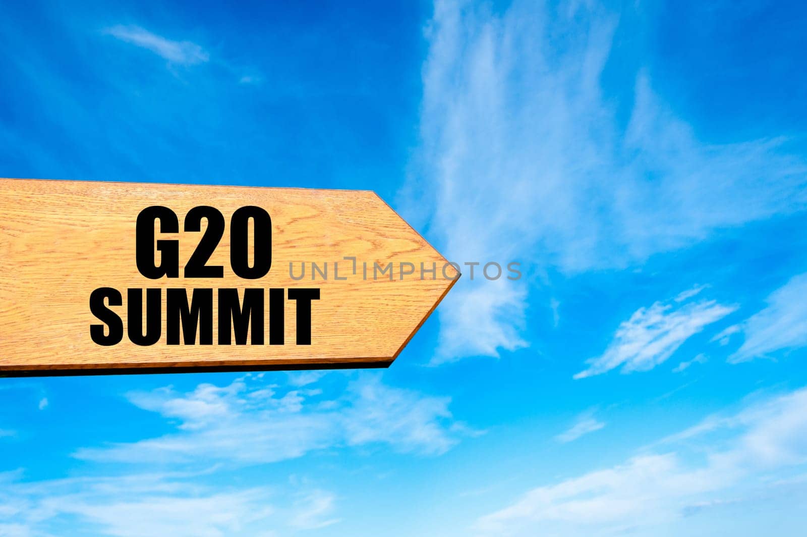 Wooden arrow sign pointing destination  G20 SUMMIT against clear blue sky with copy space available. Travel destination concept  image