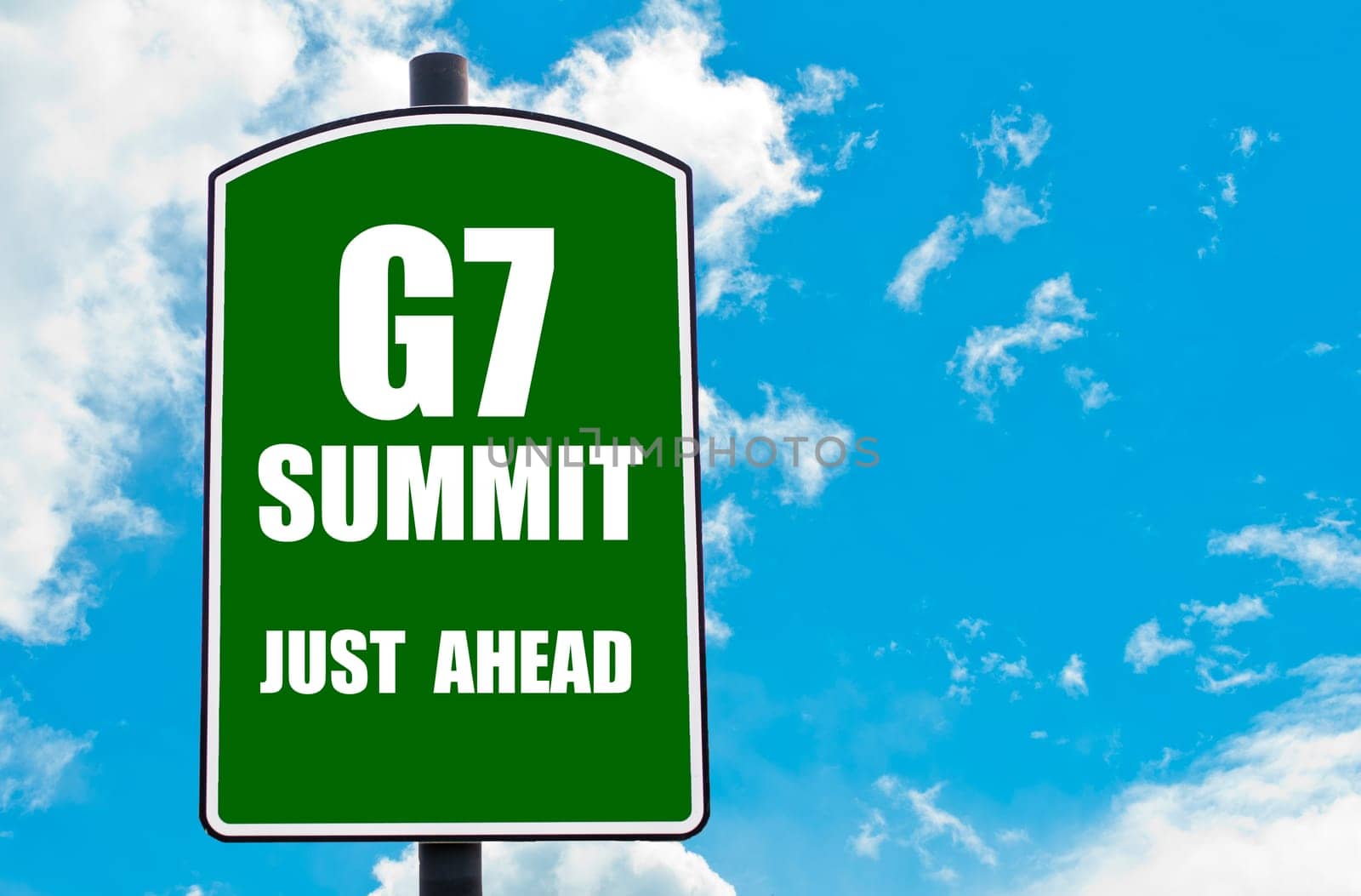 G7 SUMMIT Just Ahead written on green road sign  against clear blue sky background. Concept image with available copy space