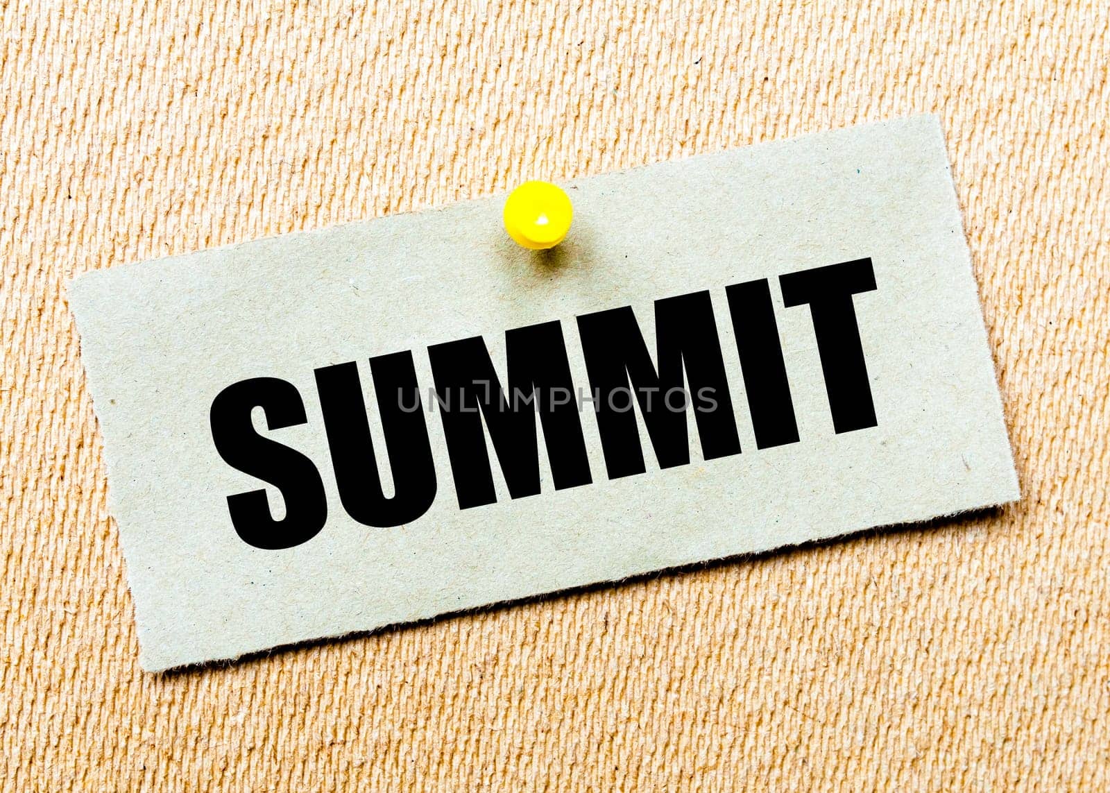 Recycled paper note pinned on cork board with word SUMMIT. Concept Image