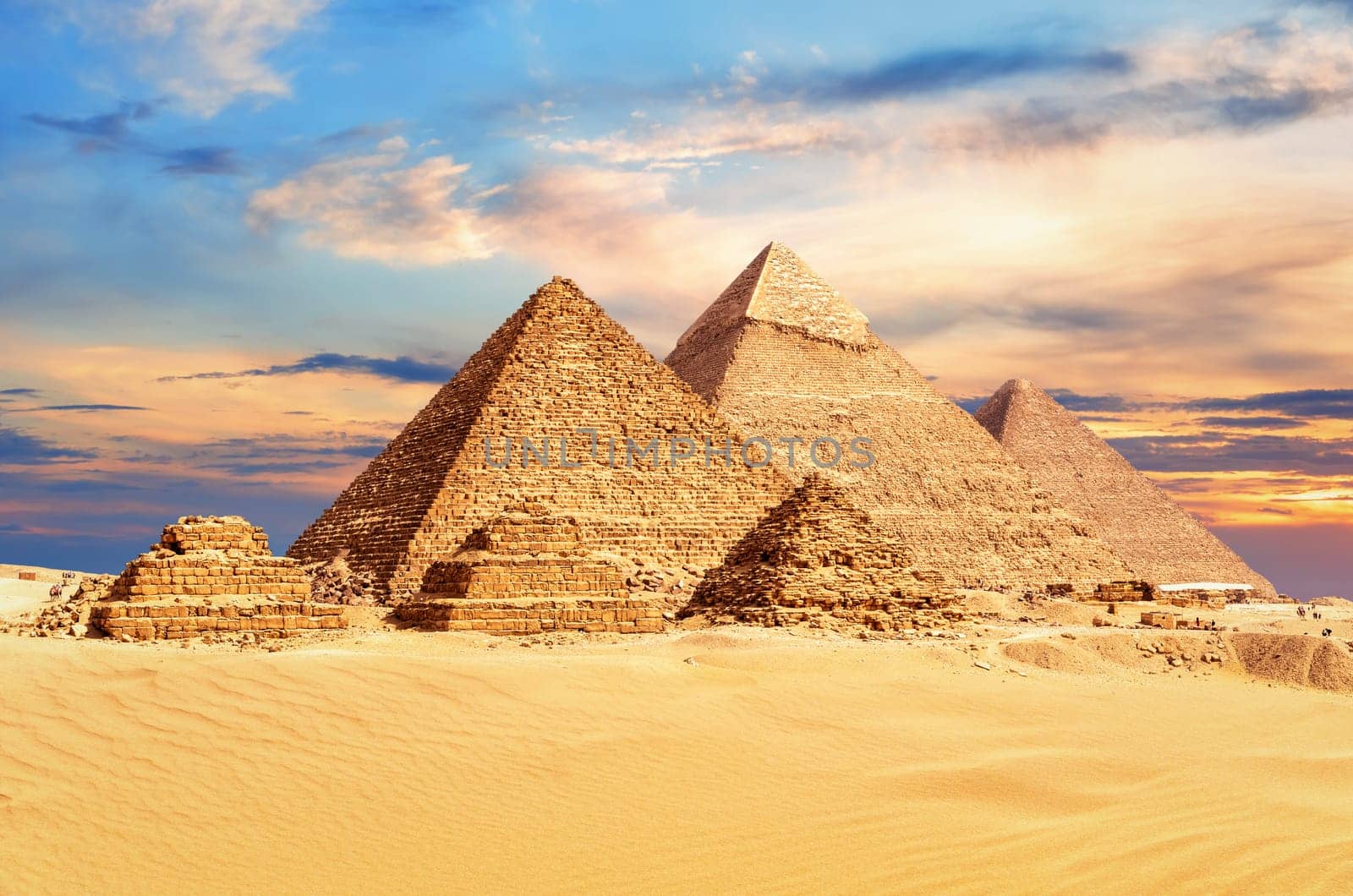 The Great Pyramids of Giza under a colorful desert sky, Egypt.