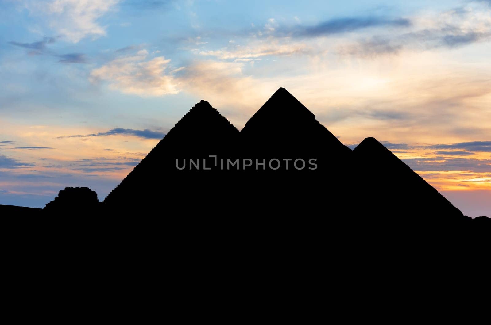 The pyramids in the dark, silhouettes at sunset, Giza, Egypt.