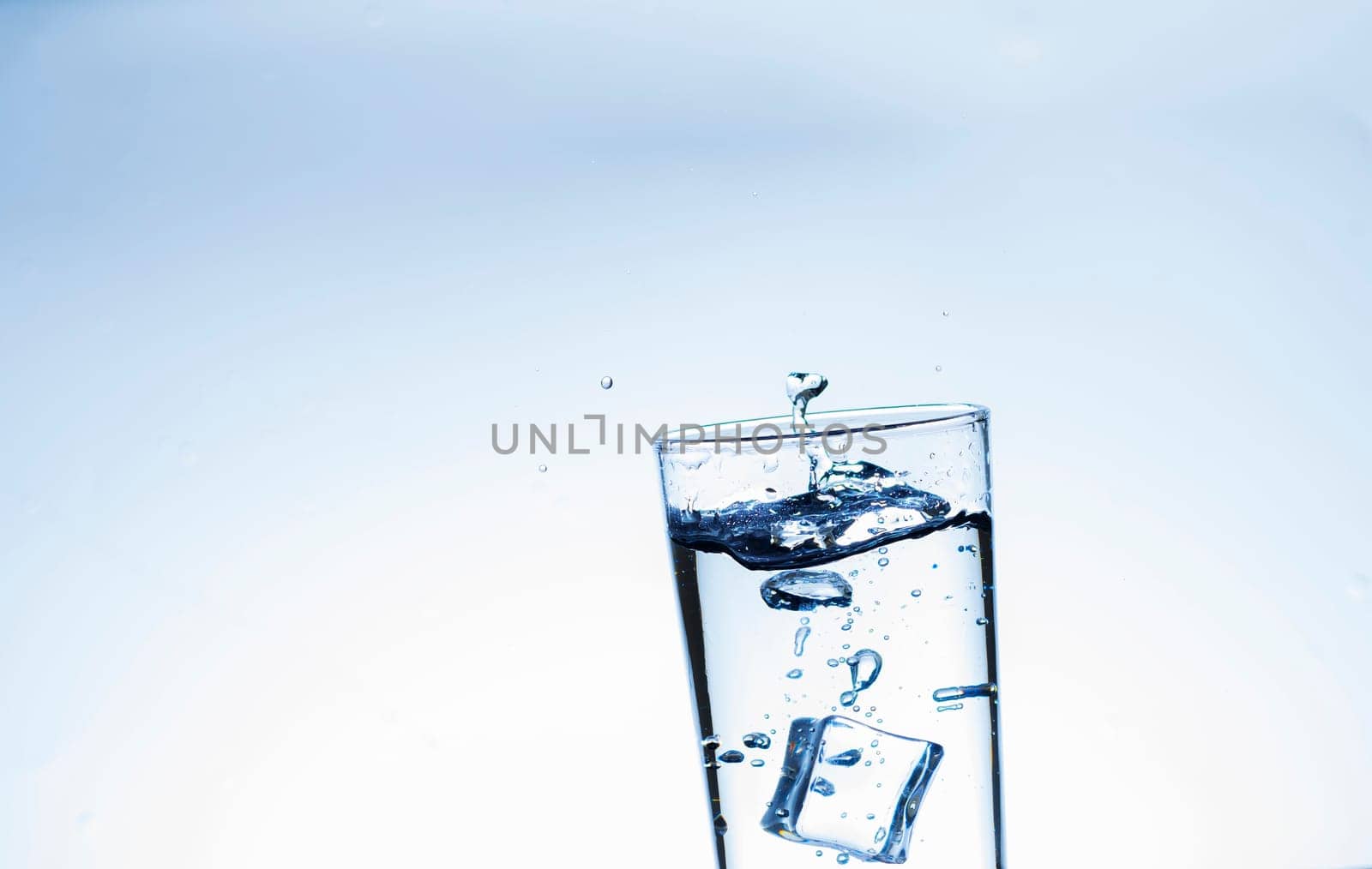 The image of pouring drinking water, into a glass, that makes one feel refreshed on blurred white background, Splashing water, Sparkling water