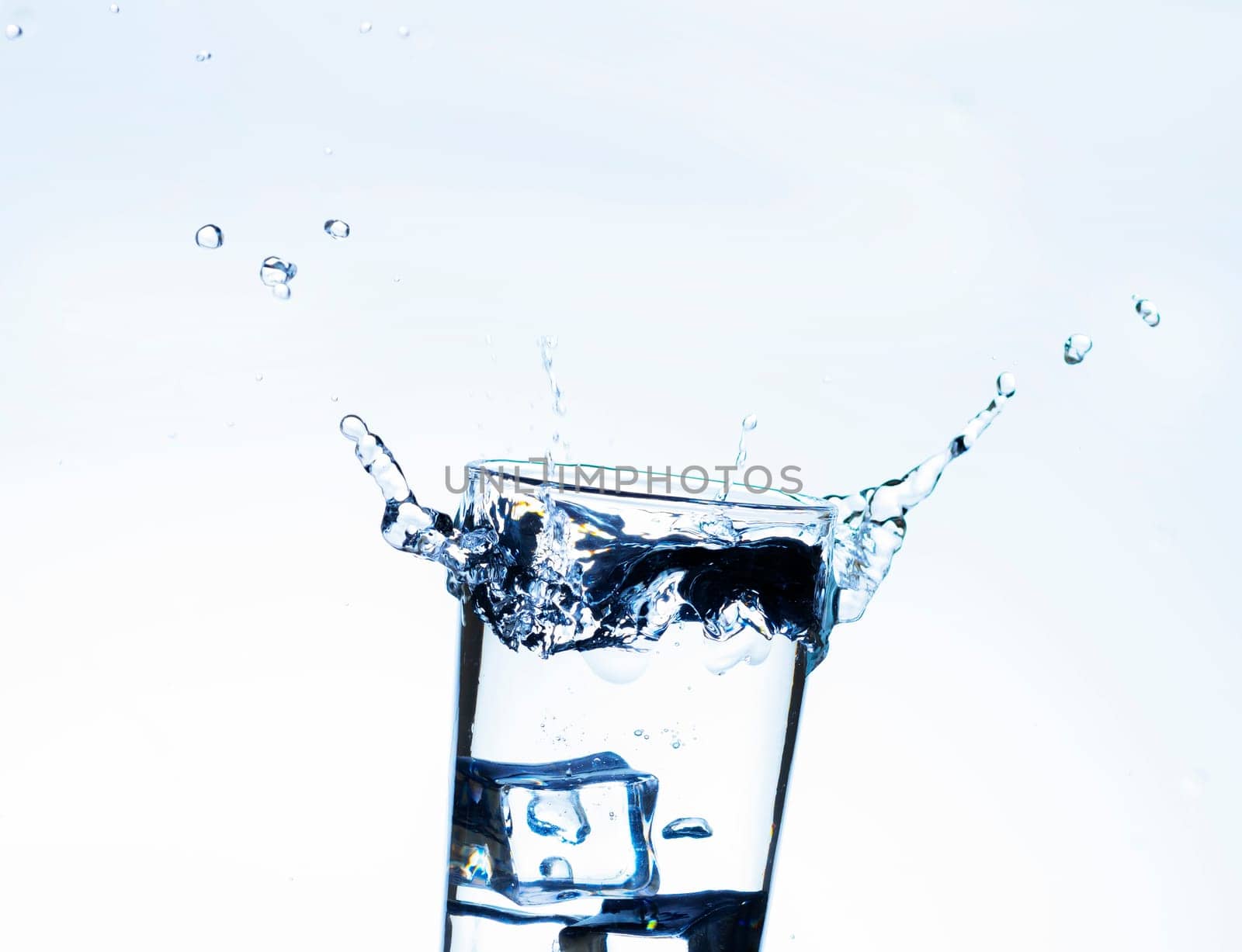 The image of pouring drinking water, into a glass, that makes one feel refreshed on blurred white background, Splashing water, Sparkling water