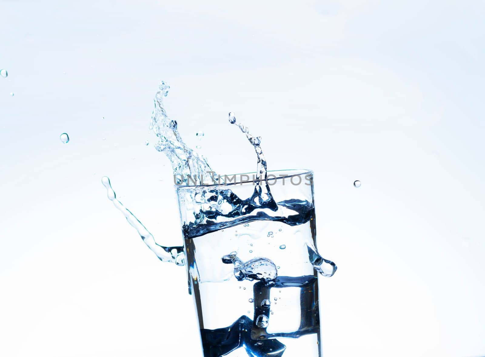 The image of pouring drinking water, into a glass, that makes one feel refreshed on blurred white background, Splashing water, Sparkling water