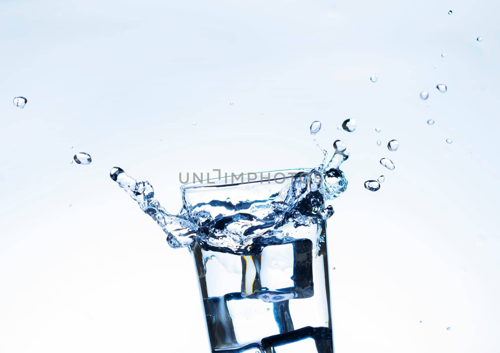 The image of pouring drinking water, into a glass, that makes one feel refreshed on blurred white background, Splashing water, Sparkling water